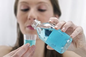 Woman pouring medicine into a bottle cap