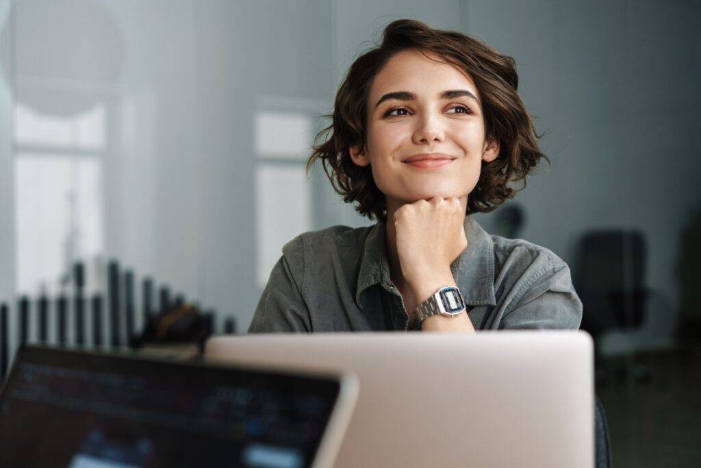 Female professional smiling in front of laptop