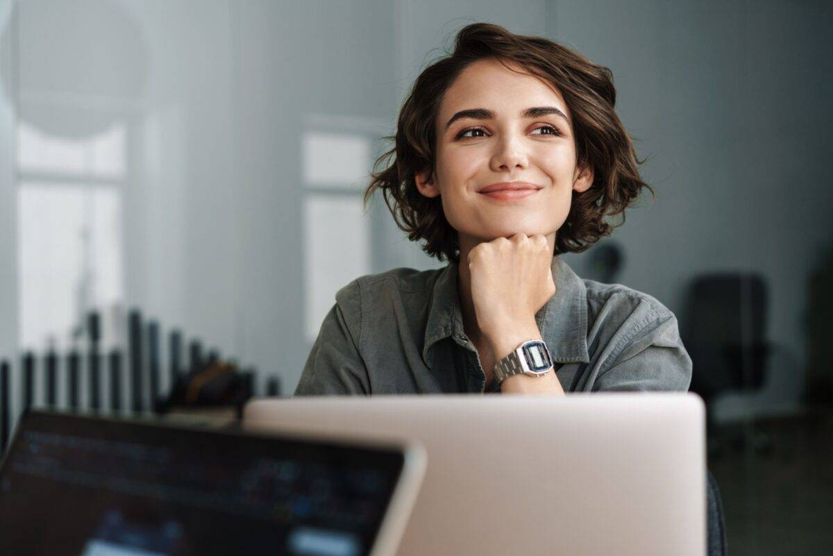 Female professional smiling in front of laptop