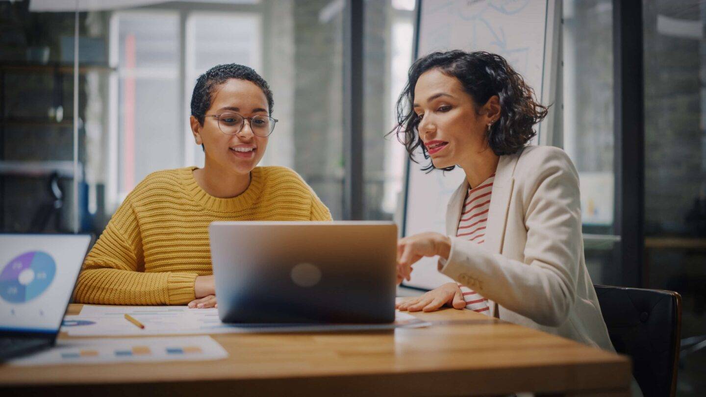 Two women working at a laptop