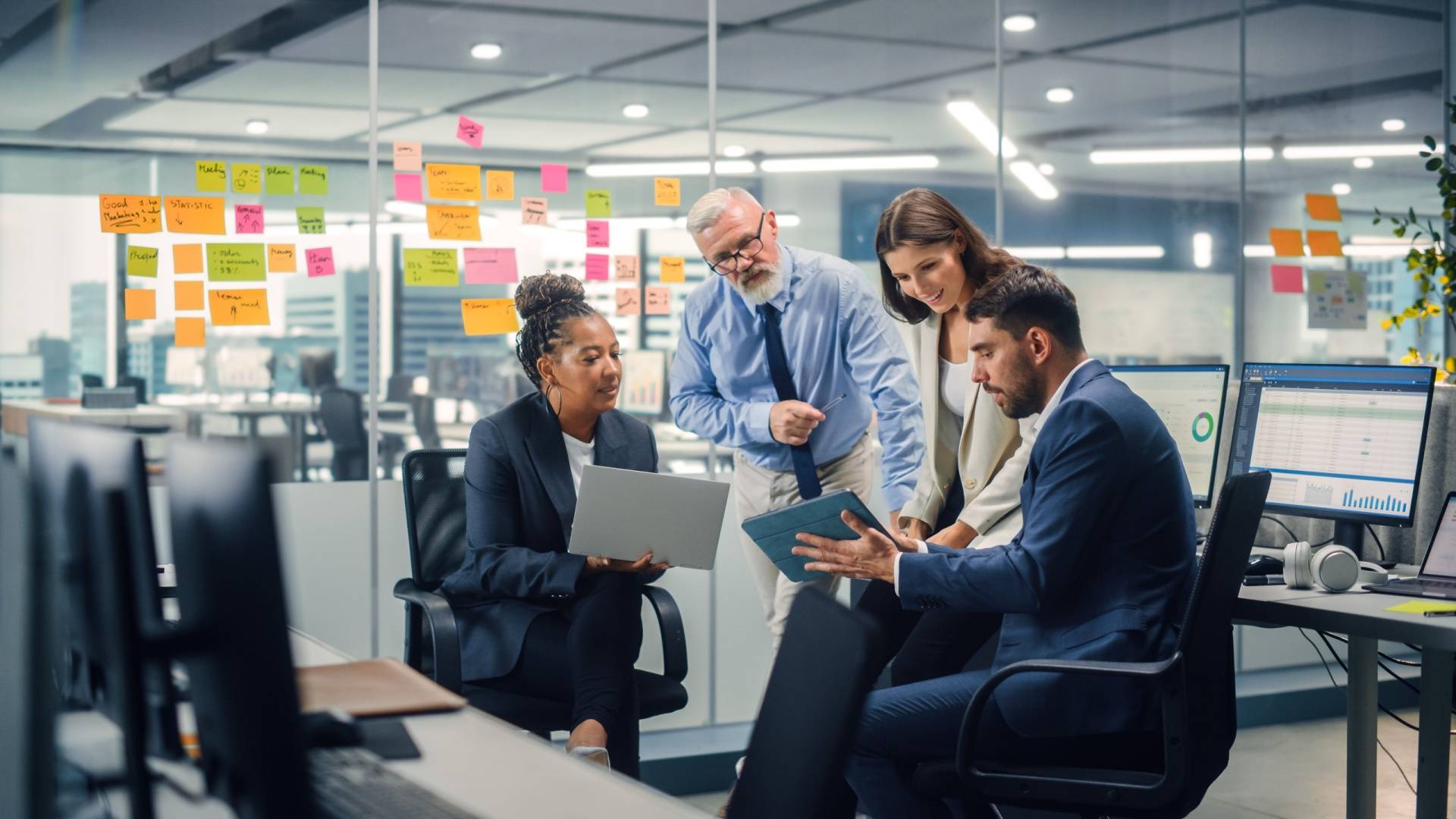 Team of working professionals in an office looking at a tablet