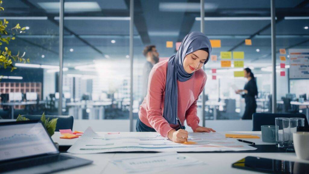 Smiling muslim female professional writing on a document in an office