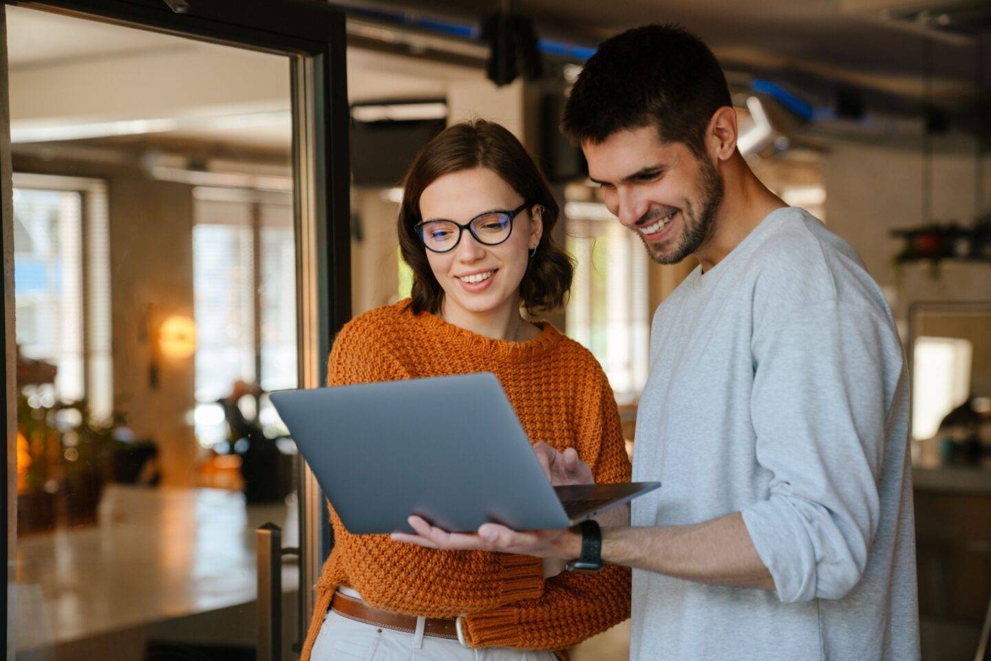 Man and woman smiling at a laptop