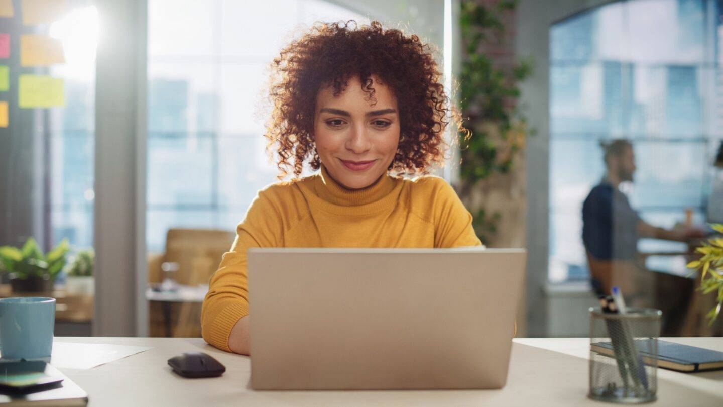 Female professional working at a laptop in an office