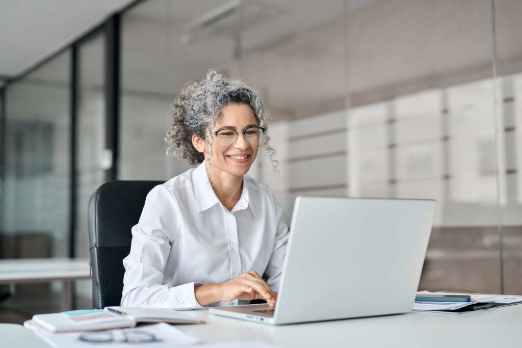 Older female professional smiling while working in an office