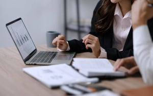 Working professionals looking at data on a laptop