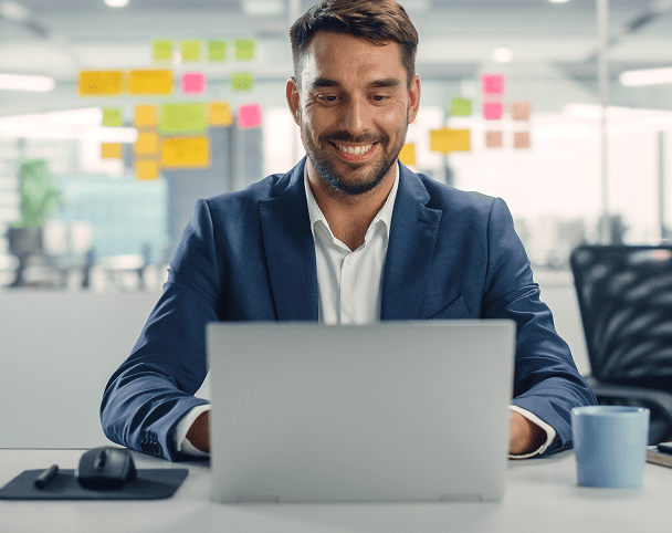 Happy business professional working at his laptop